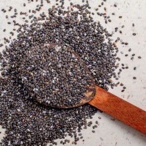 dry fruits and seeds Wooden spoon filled with chia seeds, highlighting their texture and nutritional value.