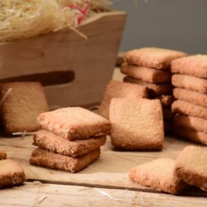 Appetizing shortbread cookies stacked on a rustic wooden surface, perfect for food photography.