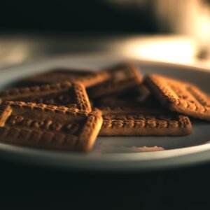 Close-up of square biscuits on a plate with warm lighting, perfect for snacks.