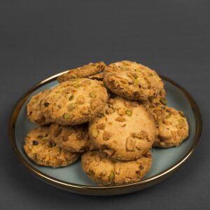 A stack of delicious nutty cookies placed on a blue plate against a dark backdrop.