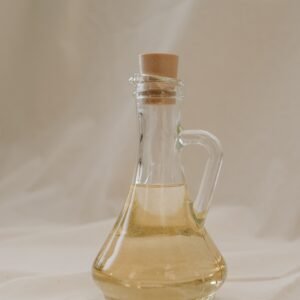 A stylish glass bottle filled with olive oil, showcasing elegance and sustainability.