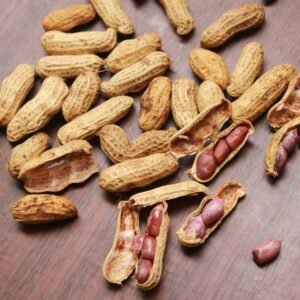 dry fruits and seeds A detailed view of peanuts in shells scattered on a wooden surface. Ideal for food themes.