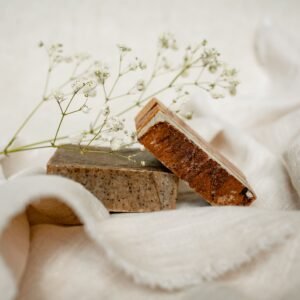 Elegant arrangement of handmade soaps with baby's breath on soft fabric.
