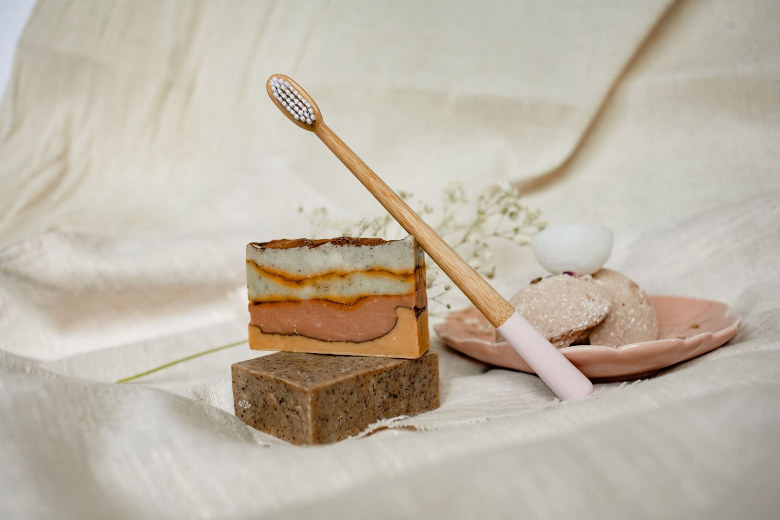 pexels photo 5420539 5420539 Sustainable bath essentials including soaps and a bamboo toothbrush on a textile surface.