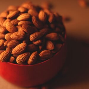 dry fruits and seeds A close-up of almonds in a red bowl, perfect for a healthy snack or nutritious eating.