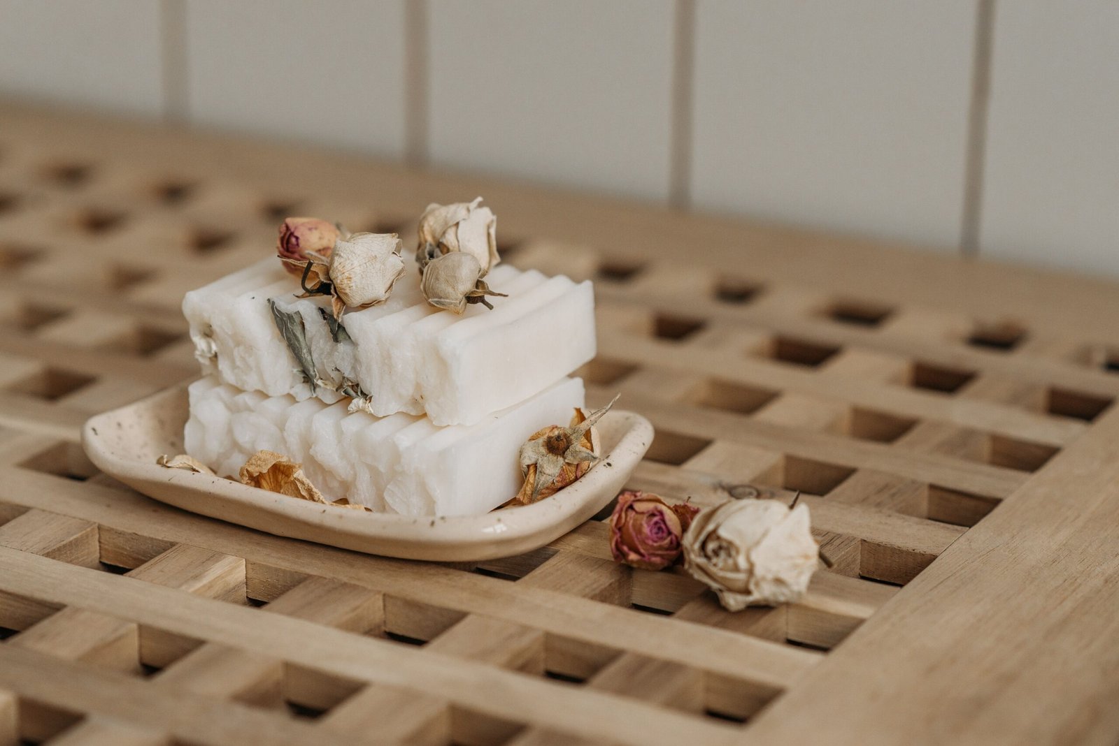 pexels photo 7055165 7055165 Close-up of natural artisan soaps adorned with dried roses on a ceramic tray, showcasing eco-friendly living.