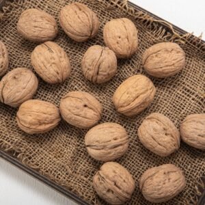 dry fruits and seeds High-angle shot of whole walnuts on a burlap-lined tray, showcasing natural textures.