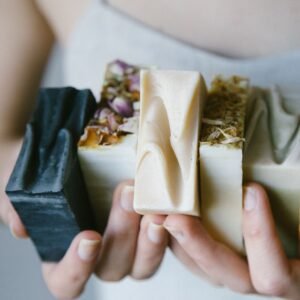 A variety of handcrafted organic soaps held in hands, showcasing natural ingredients and textures.