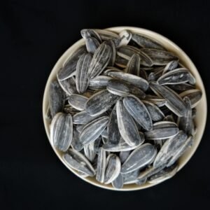 dry fruits and seeds Bowl of sunflower seeds on a black background, perfect for healthy food themes.