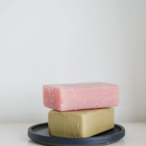 Two soap bars neatly stacked on a tray against a white background.